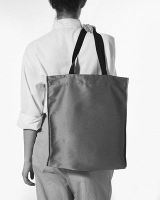 a woman is wearing the grey aldine silk shopper bag|light