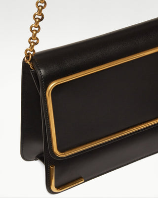 detailed view of the black gala leather satchel bag, gold plated chain and hardware|light