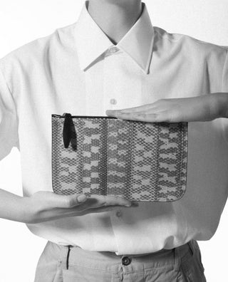 holding the vanni exotic snake skin pouch with a pocket|light