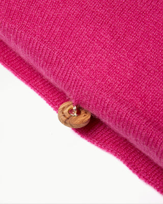 close up view of the pink small striped dolce cashmere travel pillow with olive wood buttons|light